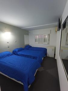 特尔马斯德里奥翁多Hotel FG的一间设有四张蓝色床铺的房间