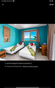 苏梅岛Villa bien-être avec coach sportif et Chef Thaï Bophut koh Samui的一间卧室设有两张床和蓝色的墙壁