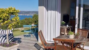 克尼斯纳Knysna Private Estate Lagoon Apartment - Garden Apartment - Secure Estate的一个带桌椅的海景庭院
