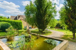 维特拉克La Barde Montfort, votre maison d'hôtes à 4 kms de Sarlat Dordogne的中间有一个池塘的花园