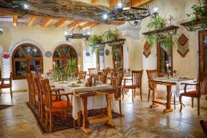 乌奇希萨尔Petra Inn Cappadocia的一间在房间内配有桌椅的餐厅