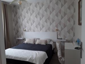 阿姆博斯Chez Zabou的一间卧室配有一张床和灰色白色图案的墙壁