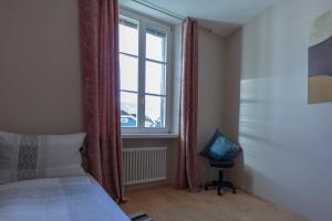 阿皮亚诺苏拉斯特拉达Apartment Perwanger的一间卧室设有一张床、一个窗口和一把椅子