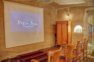 乌奇希萨尔Petra Inn Cappadocia的一间会议室,配有椅子和投影屏幕