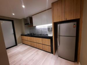 马六甲Melaka Homestay Best in Town 6+3 paxs的厨房配有不锈钢冰箱和木制橱柜