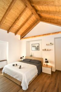 马莱斯科La Terrazza的一间卧室设有一张大床和木制天花板。