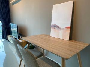 莎阿南Trefoil Studio Comfy 3-Shah Alam的一张带椅子的木桌和墙上的绘画