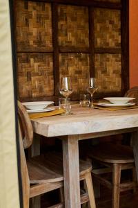 普罗奇达Procida Camp & Resort - La Caravella的一张木桌,上面放有酒杯和盘子