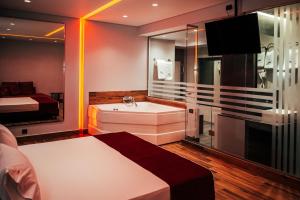 雅典派内斯酒店的带浴缸、床和电视的浴室