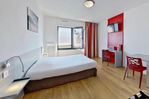 塞纳河畔伊夫里城市艾弗里酒店的酒店客房配有一张床、一张桌子和一把椅子。