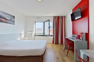 塞纳河畔伊夫里城市艾弗里酒店的酒店客房设有一张大床和一张书桌。