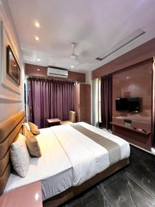 苏拉特Hotel Czar Inn的酒店客房设有一张大床和一台电视机。