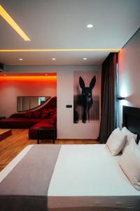 雅典派内斯酒店的卧室配有一张床,墙上挂着一幅兔子画