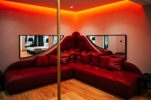 雅典派内斯酒店的客厅配有红色沙发和两面镜子