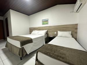 塞古罗港Hotel Casa Blanca Porto Seguro的一间客房内配有两张床的房间