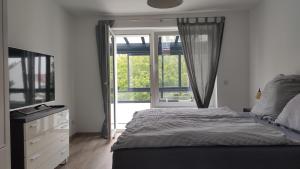 罗斯托克Wohnung Meeresbrise 48 qm mit Balkon的一间卧室设有一张床和一个大窗户