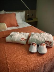 Amir Hotel Boutique CA的床上的2条毛巾和2条拖鞋
