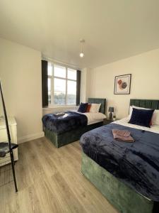 弗特威克Flitwick Luxury 3 Bedroom Apartment的一间卧室设有两张床和窗户。