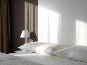 楚格City Apartments的一张带枕头的床和一盏靠窗的灯