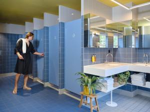 鹿特丹鹿特丹市中心旅舍的女人站在蓝色的浴室里