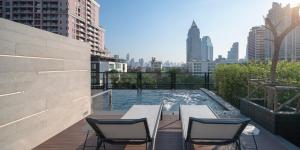 曼谷PASSA Hotel Bangkok的一座带椅子的庭院和一座位于大楼内的游泳池