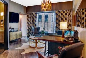 纽约Roxy Hotel New York的客厅配有桌椅和窗户。