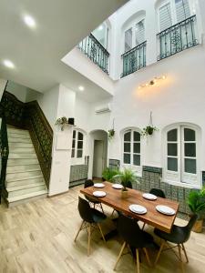 塞维利亚Triana Riverside Guesthouse的一间带木桌和椅子的用餐室