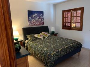 科斯塔特吉塞One bedroom bungalow Playa Bastian Costa Teguise的一间卧室配有一张床、两盏灯和一个窗户。