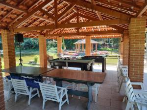 迈林克Sitio da Rose的庭院设有2张乒乓球桌和白色椅子