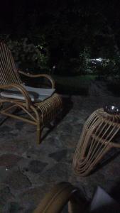 LinROLEO Guest House的夜晚坐在石头庭院的藤椅