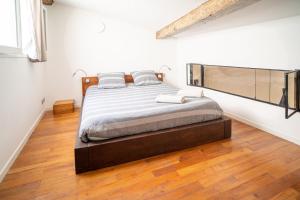 蒙彼利埃L'Agora Home HH - Centre Historique Corum - Netflix & Prime Video的一间卧室设有一张大床,铺有木地板
