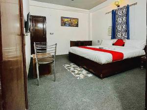 新德里OYO Kings Court的一间卧室配有一张床和一把椅子