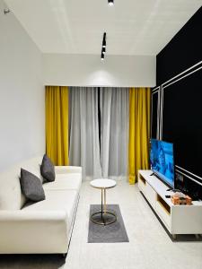 吉隆坡KLCC Suites At Axon Residence的客厅配有白色沙发和电视