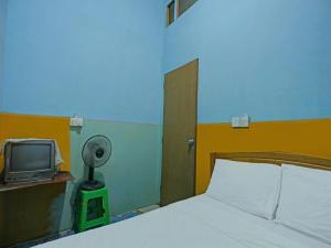 名古屋SPOT ON 92985 Mitra Homestay的一间卧室配有一张床和电视