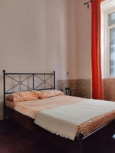 那不勒斯La scalinata apartment的一间卧室配有一张带橙色窗帘的床