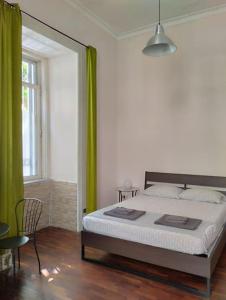 那不勒斯La scalinata apartment的一间卧室配有一张带绿色窗帘的大床