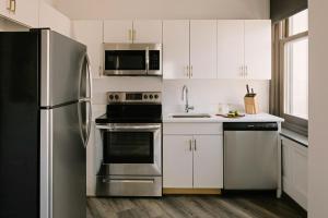 底特律Sonder Gabriel Richard的厨房配有白色橱柜和不锈钢冰箱
