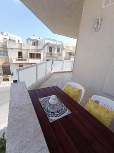 Siġġiewi"Joseph 2" Stylish corner flat with open views, just 5km from the beach的屋顶阳台配有木桌和椅子
