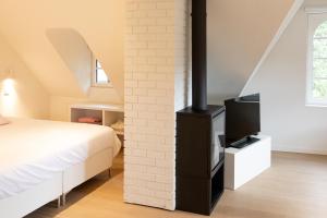 德哈恩Doux Foyer的一间卧室设有一张床和砖墙