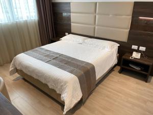 普拉托HotelLuxuryPrato的一间卧室配有一张大床和木制床头板