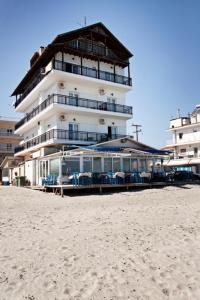 帕拉利亚卡泰里尼斯Nepheli的海滩上的一座建筑,配有椅子和遮阳伞