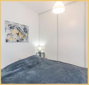 埃维昂莱班Appartement T2 Vue Lac Léman Evian les Bains的卧室配有一张床,墙上挂有绘画作品