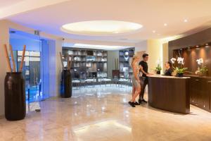 坎昆Seadust Cancun Family Resort - All Inclusive的站在大厅柜台的男女