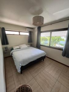 普纳奥亚Beach side Duplex的一间卧室设有一张大床和两个窗户。
