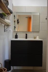 普罗旺斯艾克斯Villa ELISABETH的浴室设有黑色水槽和镜子
