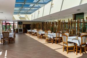 贝洛格拉奇Хотел "Скалите", Skalite Hotel的用餐室配有白色的桌子和木椅