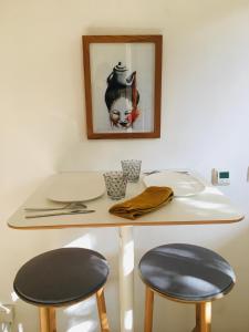 波尔多Le Patio的一张桌子、两把椅子和一张墙上的照片