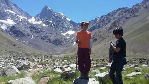 Refugio Lo ValdésHostal Crisol的两个男孩站在山中的岩石上