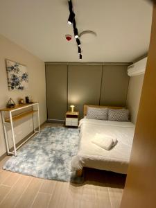 马尼拉Classy 2BR Suite at Eastwood City with Pool and City Skyline View的一间卧室配有一张床和蓝色地毯