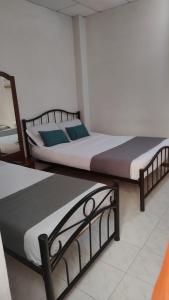 马尼萨莱斯HOTEL GIRASOLES的两张睡床彼此相邻,位于一个房间里